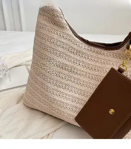 Detail of cream straw tote bag featuring dark brown leather trim and a small coin purse