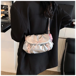Détail du sac nuage argenté avec nœuds roses et breloque à carreaux sur l'épaule
