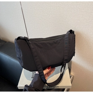Detail of minimalist black nylon crescent shoulder bag with high quality zip closure