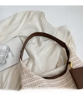 Detailed close-up of straw woven tote bag with brown faux leather straps and coin purse