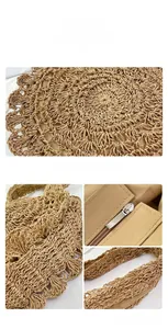 Detail view of the hand-woven texture, metal zipper, and shoulder strap of the straw beach bag
