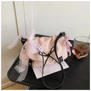 Détail du sac nuage rose avec nœud en dentelle blanche, perle et bandoulière noire