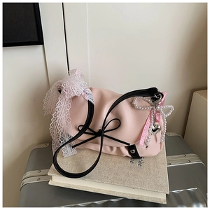 Détail du sac nuage rose avec poignée à nœud noir et ornements en dentelle fine