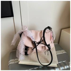 Détail du sac nuage rose avec nœud noir, ruban en dentelle et breloque en perles