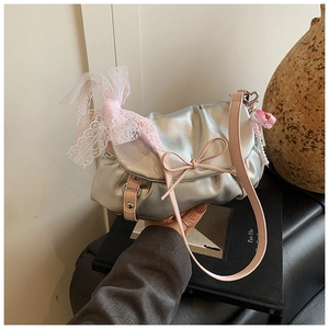Détail du sac nuage argenté avec nœud en dentelle rose, breloque perle et cuir plissé
