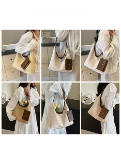 Detail view of woven straw tote bag with brown leather straps and side accessory pouch