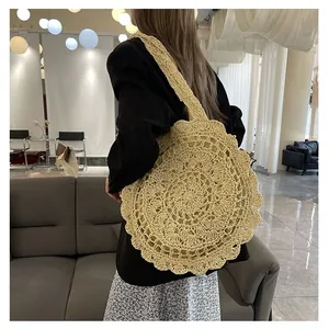 Detail of a handmade straw shoulder bag with a radial hollow crochet pattern on beige texture