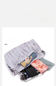 Détails de l'intérieur spacieux du sac plissé lavande avec les essentiels du quotidien