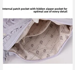 Détail de l'intérieur du sac en nylon lilas avec poches zippées et doublure logo