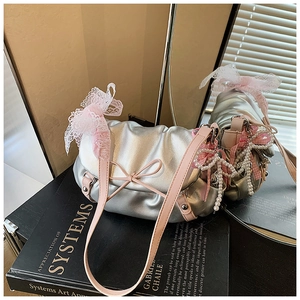 Détail du sac nuage plissé argenté avec nœud en dentelle rose et breloque en perle