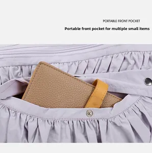 Détail du sac plissé violet clair montrant une poche avant avec un bouton-pression en métal