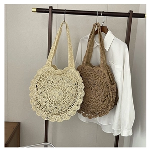 Handwoven straw beach bag with floral hollow design in beige and brown colors