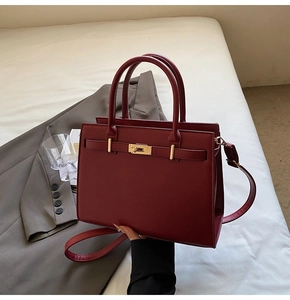 Detail of red bridal handbag showing golden twist lock and luxury lychee texture leather
