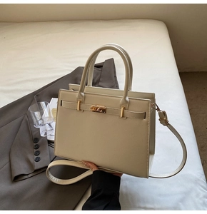 Detail of cream structured handbag with gold hardware and textured pebble leather