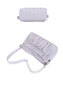 Détails d'un sac plissé violet montrant la boucle métallique et la texture du tissu