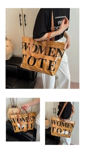 Dettaglio della grande borsa tote impermeabile in PVC con scritte nere e tracolla marrone