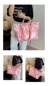 Dettaglio di una grande borsa tote rosa con scritte bianche e tracolla regolabile
