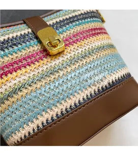 Detail of colorful woven handbag featuring a metallic gold square push-lock closure