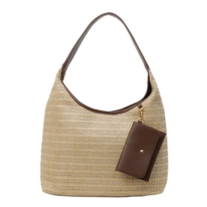 Large straw tote bag with brown leather handles and small charm for summer casual use