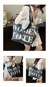 Dettaglio ravvicinato della grande borsa tote nera in pelle con scritta Women Tote bianca