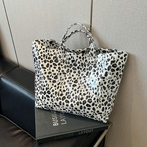 Grand sac cabas léopard brillant avec doubles poignées et texte blanc sur fond urbain