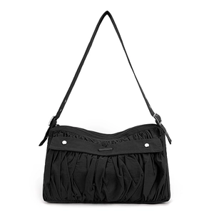 Détail du sac plissé en nylon noir avec ornements argentés et bandoulière réglable