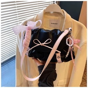 Détail du sac nuage plissé noir avec accents de nœuds roses et pendentif en perles