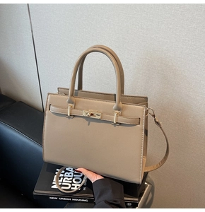 Detail of structured taupe handbag with Saffiano texture and gold-tone twist lock
