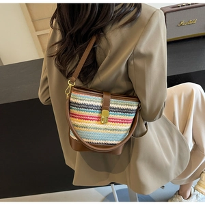 Detail view of multicolored woven bucket bag with brown leather accents and gold buckle
