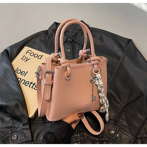 Détails du sac à main rose en cuir grainé avec pendentif clé argenté et bandoulière réglable