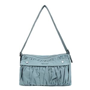 Vue détaillée de la texture plissée bleu Morandi et des boutons argentés sur le sac