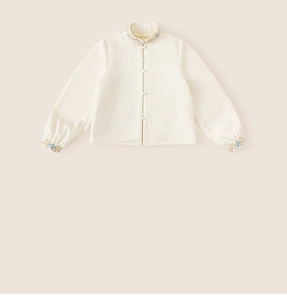 Detailed view of floral embroidery and pearl buttons on a girls Chinese style shirt