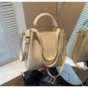 Detailed macro view of white structured tote bag with gold hardware and fine stitching