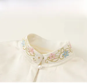 Detail of Chinese style stand collar with floral embroidery and pearl button on silk top