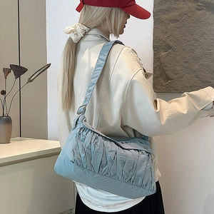 Détail du sac à bandoulière plissé bleu clair en tissu léger avec large bandoulière