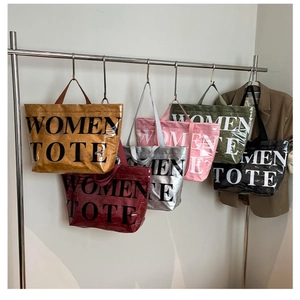 Dettaglio di borse tote colorate lucide con scritte Women Tote e design alla moda