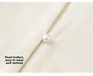 Detail of white pearl button and floral jacquard pattern on kids Chinese style shirt