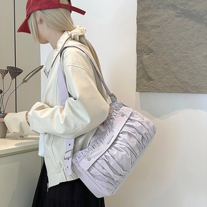 Détail du sac à bandoulière plissé lilas montrant le tissu froncé et la sangle réglable