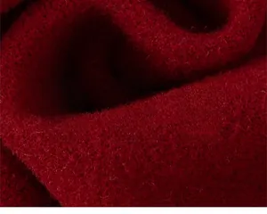 Primo piano del morbido tessuto a maglia rosso scuro con fibre lisce e alta densità