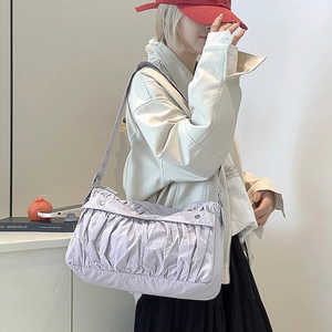 Détail du sac à bandoulière plissé violet clair montrant le nylon et la sangle réglable