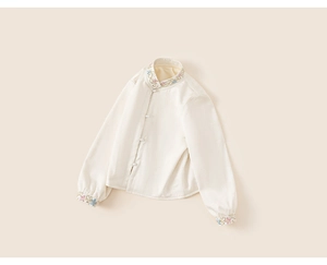 Detailed close-up of traditional Chinese style girl shirt with floral embroidery and pearl buttons