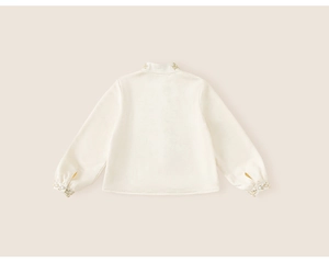 Detailed back view of children's cream blouse with elegant gold embroidery on the collar