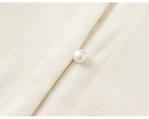 Detail of elegant pearl button and jacquard bamboo pattern on girls' traditional shirt