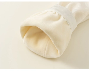 Detailed macro view of warm white satin fabric with thick velvet lining on sleeve cuffs