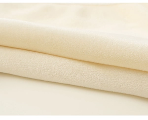 Detailed macro view of soft cream thickened fleece fabric for warm winter shirts