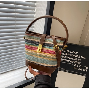 Close-up of multicolored woven texture with premium brown leather strap and gold buckle