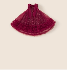 Dettaglio dell'abito in tulle rosso vino con pois dorati e fiocco per bambina