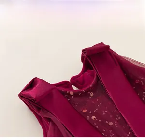 Dettaglio del corpetto in velluto rosso e dello scollo in rete con paillettes del vestito