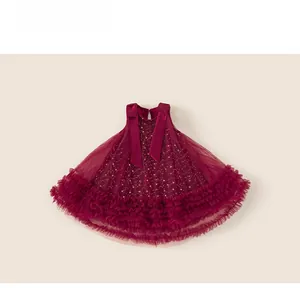 Dettaglio dell'abito in tulle bordeaux con fiocco di velluto e rete con paillettes