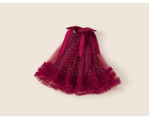 Dettaglio della gonna in tulle rosso scuro con paillettes dorate e fiocchi di raso